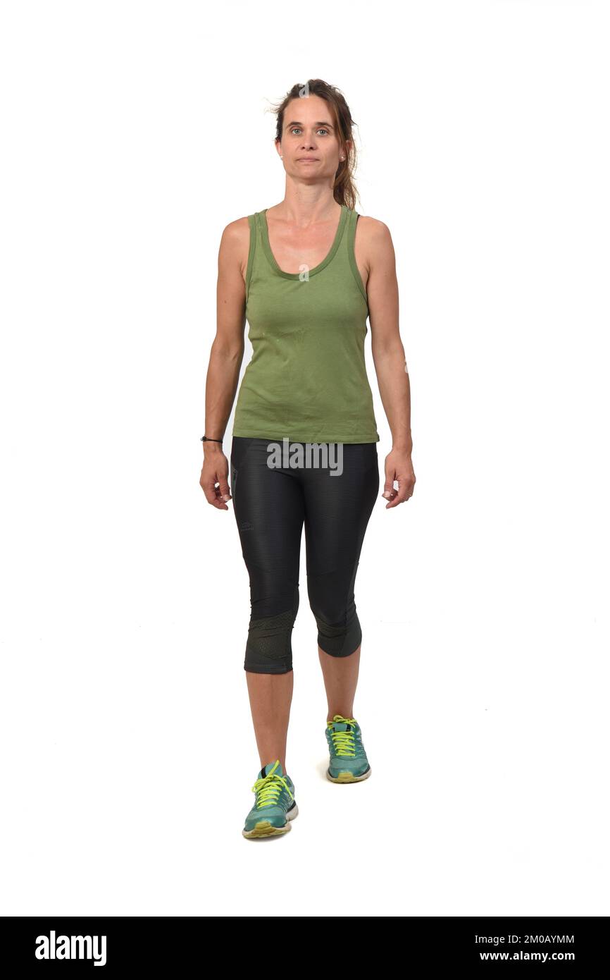 Vorderansicht einer seriösen Frau mit Sportbekleidung, die auf weißem Hintergrund läuft, Stockfoto