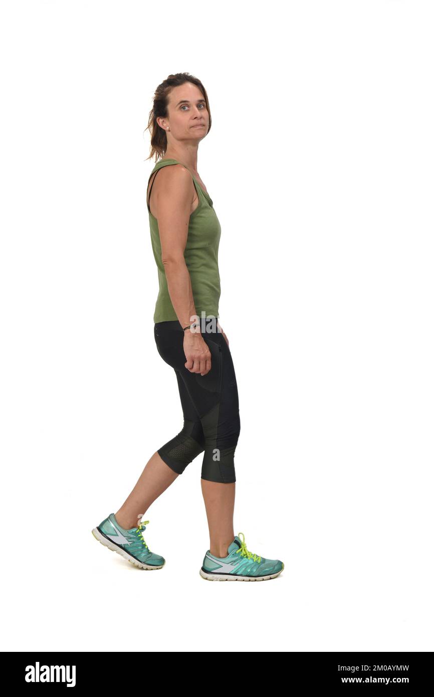 Seitenansicht einer Frau mit Sportbekleidung, die auf weißem Hintergrund in die Kamera schaut. Stockfoto