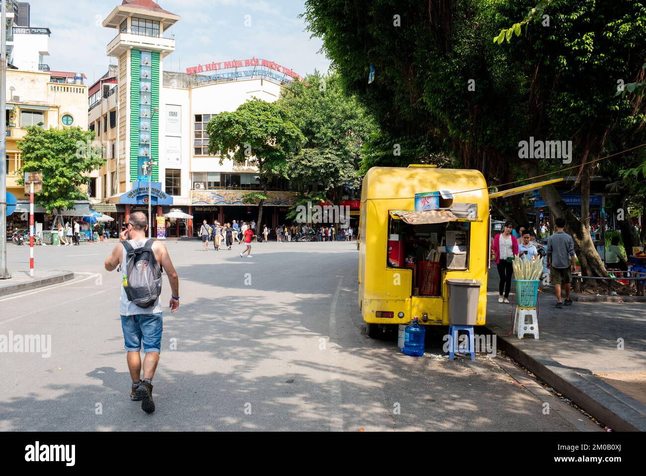Hanoi, Vietnam - 16. September 2018: Erkundung von Hanoi: Ein Tourist in Shorts und Wanderstiefeln geht an einem Straßenstand im Stadtzentrum vorbei Stockfoto