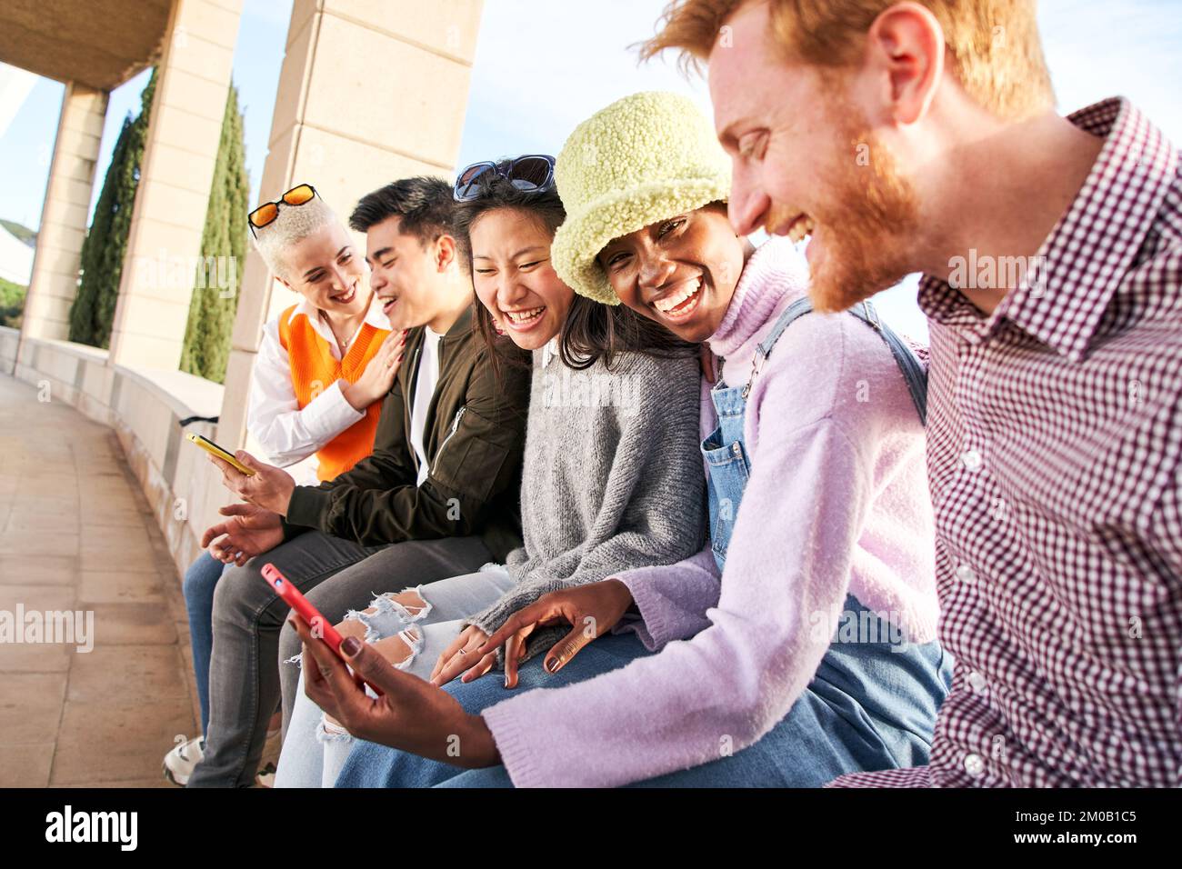 Gruppe junger Menschen gemischter Rassen mit Mobiltelefonen. Aufgeregte Schüler, die Zellen benutzen. Konzept von jungen Unternehmergeist, freundlich, Selfie, App, Hipster Stockfoto