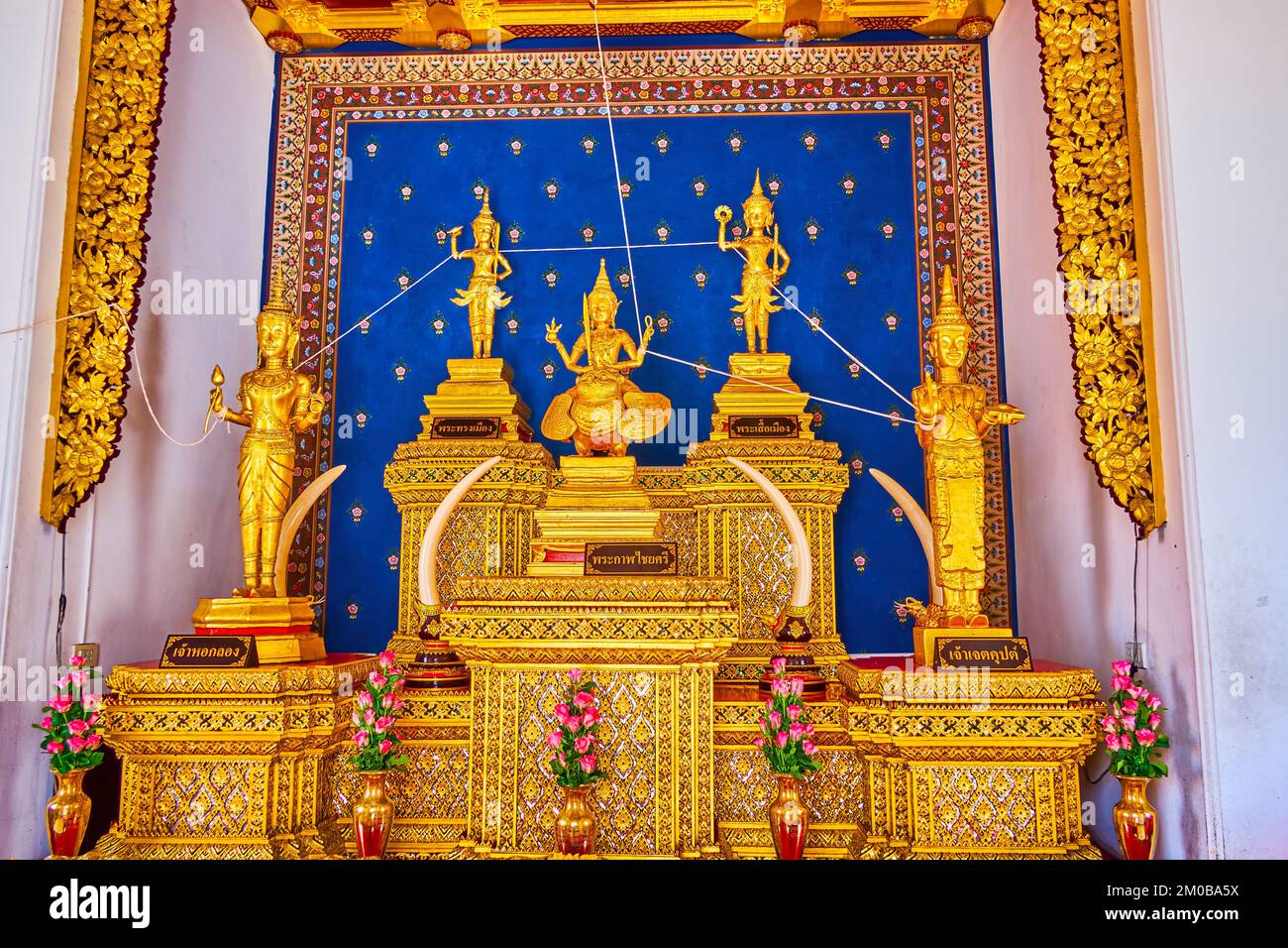 Der Altar im Säulenschrein der Stadt mit vergoldeten Figuren und Blumenmustern, San Lak Mueang in Bangkok, Thailand Stockfoto