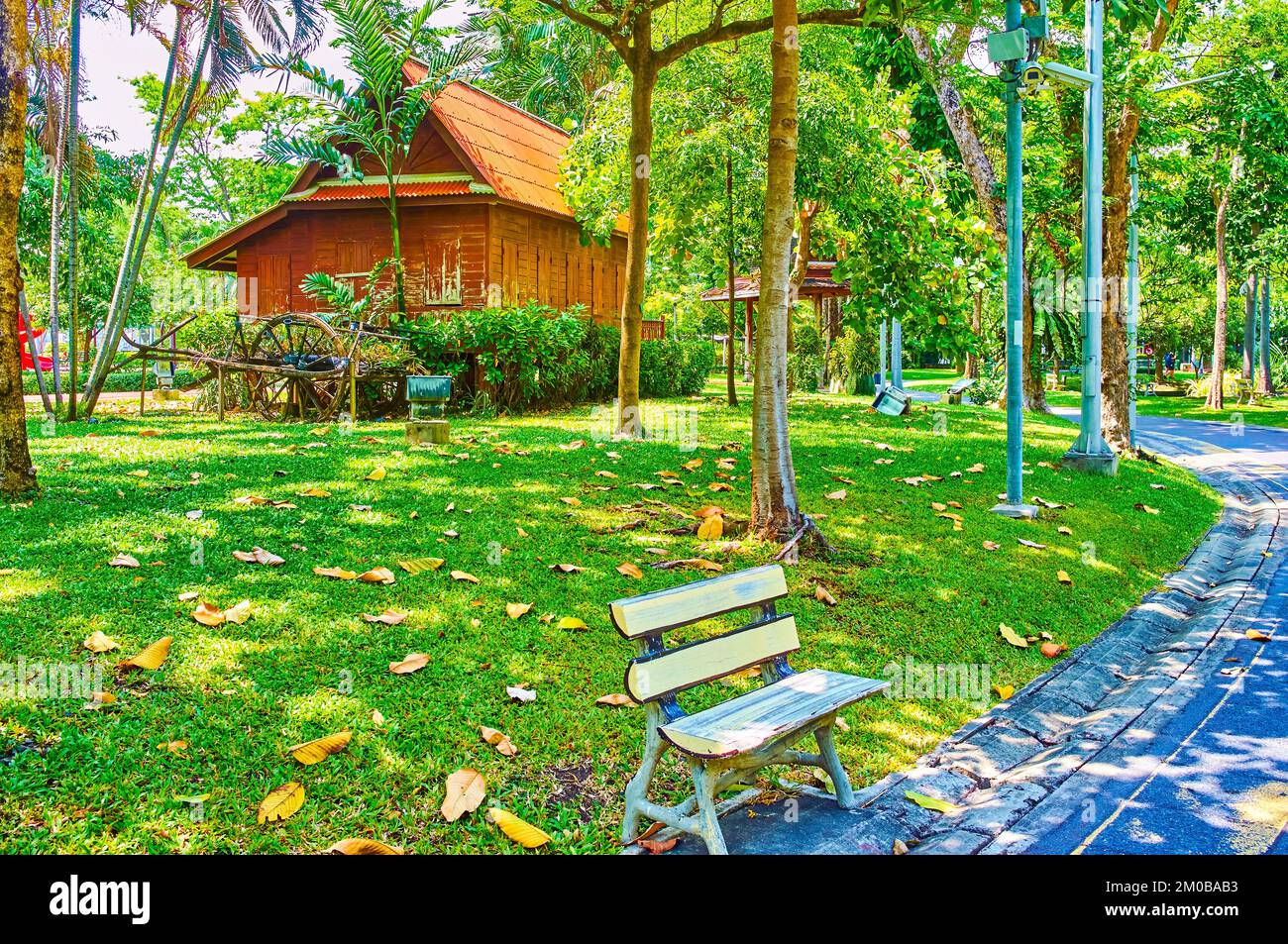 Kleine Holzbank in der Gasse im Saranrom Palace Park von Bangkok, Thailand Stockfoto