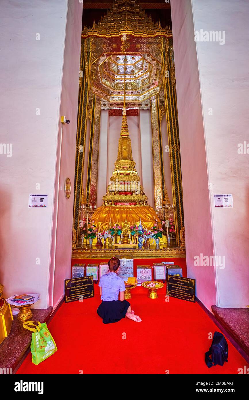 BANGKOK, THAILAND - 23. APRIL 2019: Die junge Dame betet am Goldenen Stupain Phra Mondop-Schrein des Wat Mahathat-Tempels am 23. April in Bangkok, Thai Stockfoto