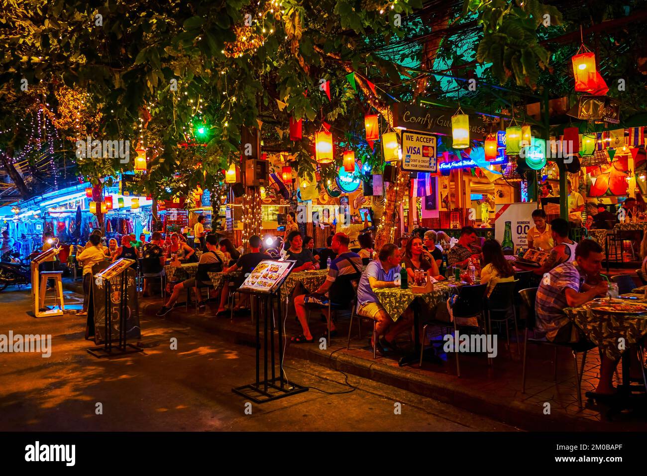 BANGKOK, THAILAND - 23. APRIL 2019: Das malerische Restaurant im Freien unter dem banyan Tree, das an der Khaosan Road am 23. April in Bangkok aufhängt Stockfoto