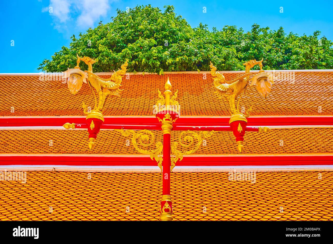 Die malerische Straßenbeleuchtung mit geschnitzten goldenen Vögeln im Innenhof des Wat Mahathat Tempels von Bangkok, Thailand Stockfoto