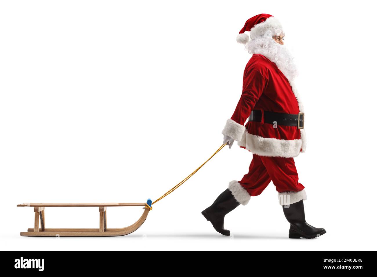 Profilaufnahme über die gesamte Länge, auf der der weihnachtsmann einen Holzschlitten zieht, isoliert auf weißem Hintergrund Stockfoto