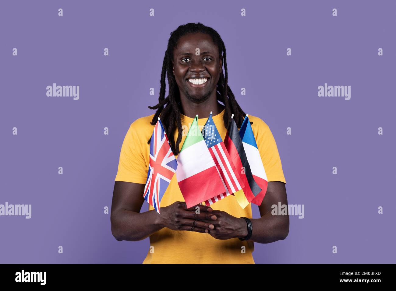 Ein glücklicher afroamerikanischer Typ mit verschiedenen Flaggen Stockfoto