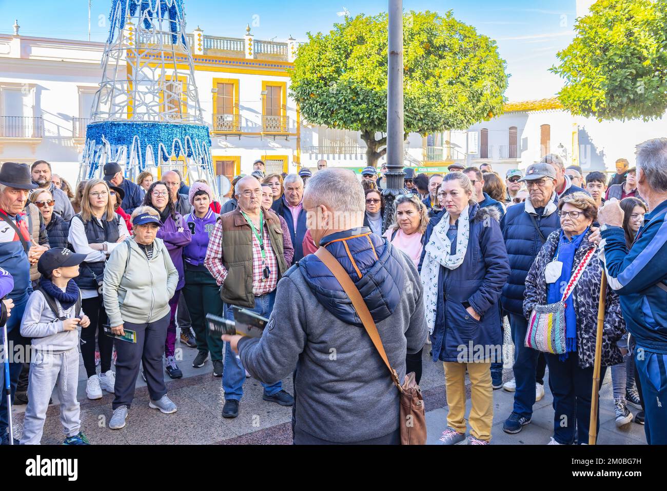 Huelva, Spanien - 4. Dezember 2022: Eine Touristengruppe, die eine geführte kulturelle Besichtigung des Dorfes Beas und der umliegenden Fabriken und Industrie beginnt Stockfoto