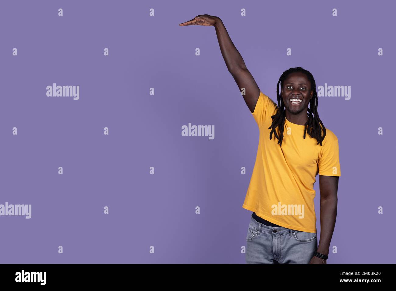 Ein fröhlicher afroamerikanischer Typ, der etwas Unsichtbares zeigt Stockfoto