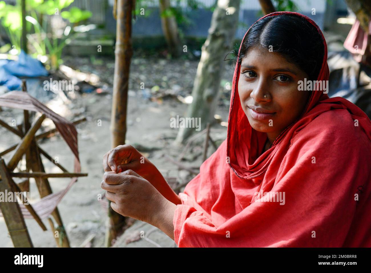 BANGLADESCH, Bezirk Tangail, Kalihati, Dorf Southpara, Hüttenindustrie, Junge Frau, die in Spinning Machine arbeitet / BANGLADESCH, Distrikt Tangail, Kalihati, Dorf Southpara, Textilindustrie, junge Frau arbeitet in einer kleinen Spinnerei Stockfoto