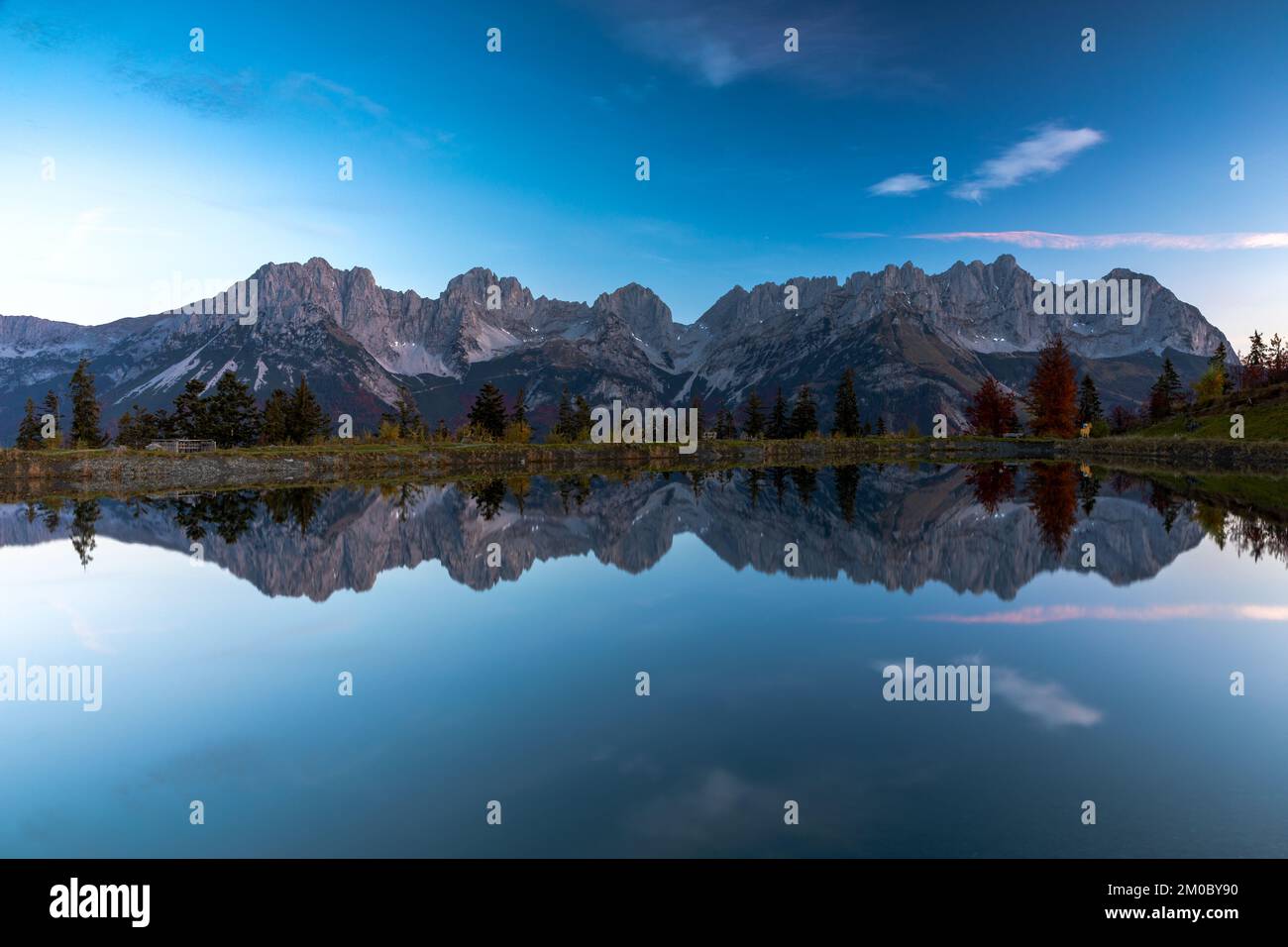 Die Berge des Wilden Kaiser spiegeln sich am frühen Morgen im Astbergsee, Going, Tirol, Österreich Stockfoto