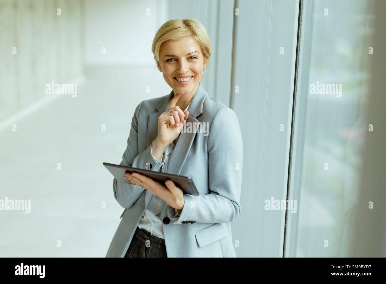 Hübsche Geschäftsfrau mit digitalem Tablet im Büroflur Stockfoto