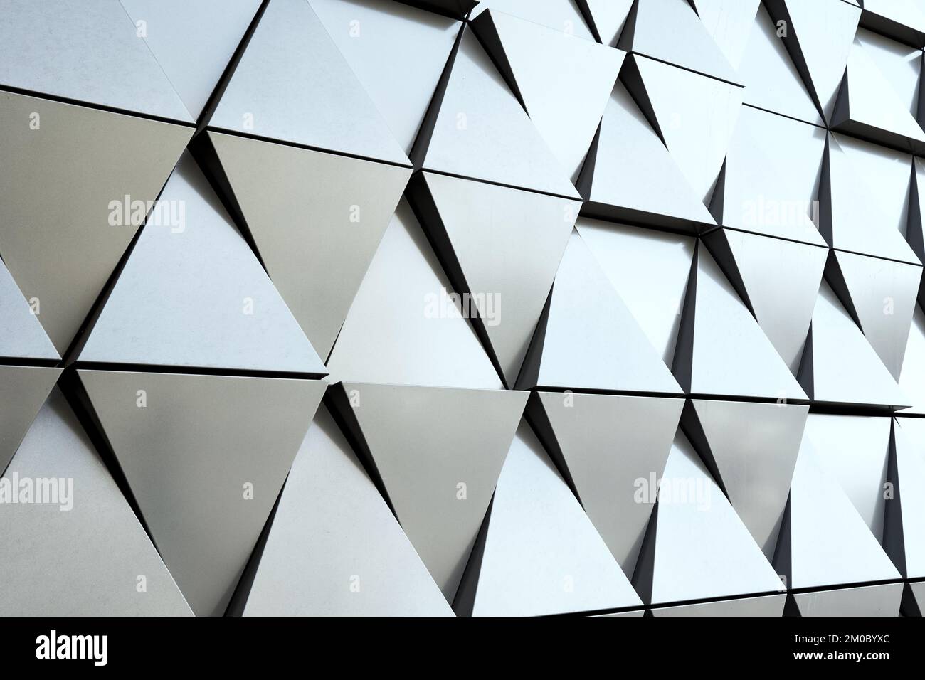 Silberne Wandfassade mit geometrischen Formen und Dreieckselementen. Abstraktes Muster für Architekturdetails. Minimaler abstrakter Hintergrund Stockfoto Silberne Wandfassade mit geometrischen Formen und Dreieckselementen. Abstraktes Muster für Architekturdetails. Minimaler abstrakter Hintergrund Stockfoto