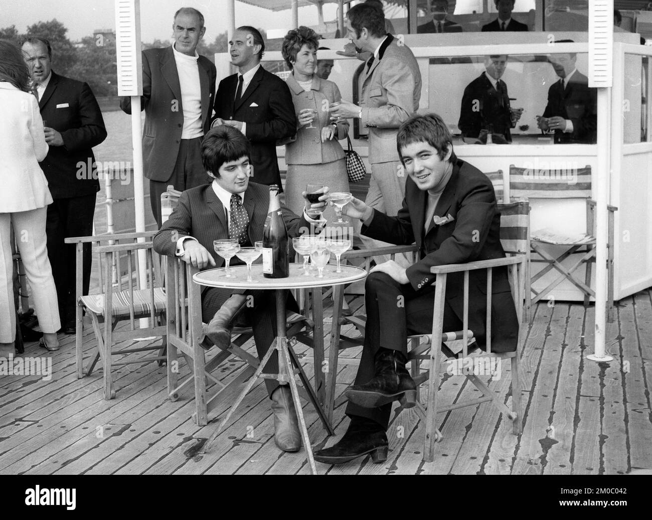 Die Popstars Paul und Barry Ryan trinken 1967 Champagner auf einem Partyboot auf der Themse in London Stockfoto