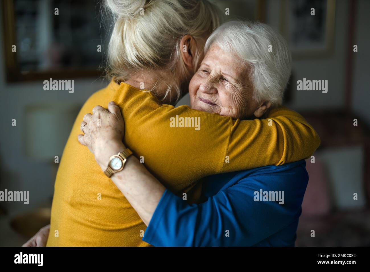 Eine Frau umarmt ihre ältere Mutter Stockfoto