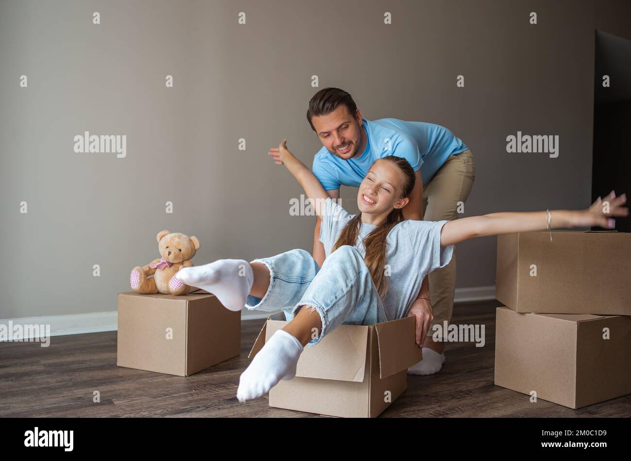 Familie von Vater und liebenswerte Teenager-Tochter haben Spaß am Umzugstag in ihrem neuen Zuhause Stockfoto