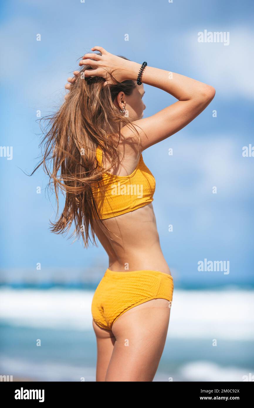 Bezauberndes, schlankes Mädchen im Badeanzug mit einer perfekten Figur am Strand Stockfoto