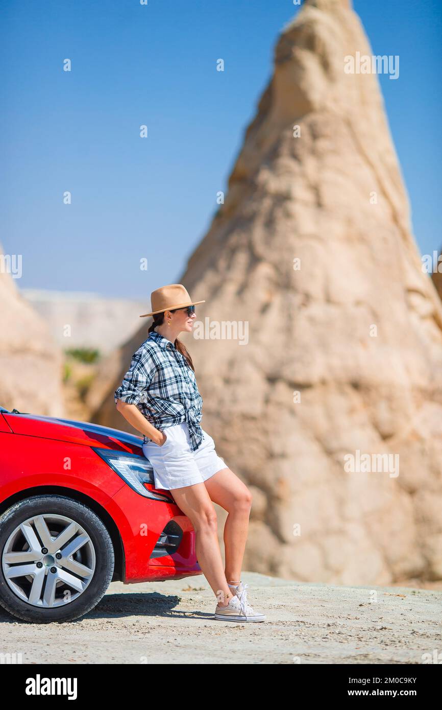 Junge glückliche Frau im Urlaub mit dem Auto in Kappadokien. Höhlenformationen. Stockfoto