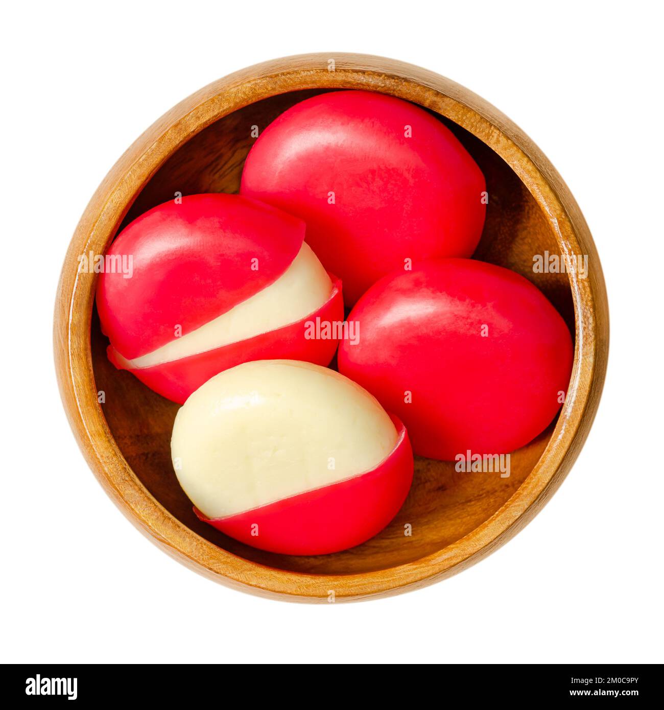Imbiss-Käsescheiben in roten Wachsgehäusen, in einer Holzschüssel. Kleine edamer-Scheiben, jeweils mit einer Mischung aus rotem Paraffin umhüllt. Stockfoto