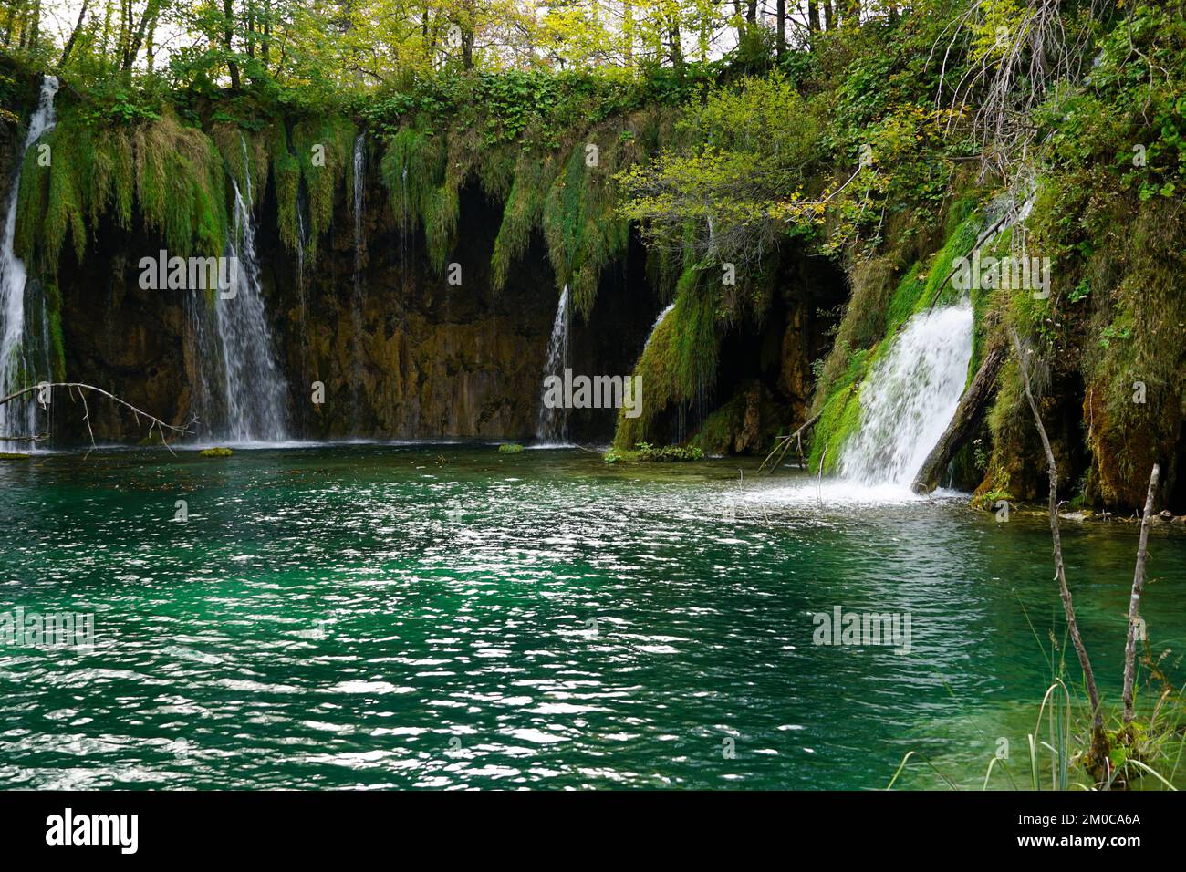 Eine fantastische Bucht mit türkisfarbenem See und kleinen Wasserfällen in einem tiefen Wald Stockfoto