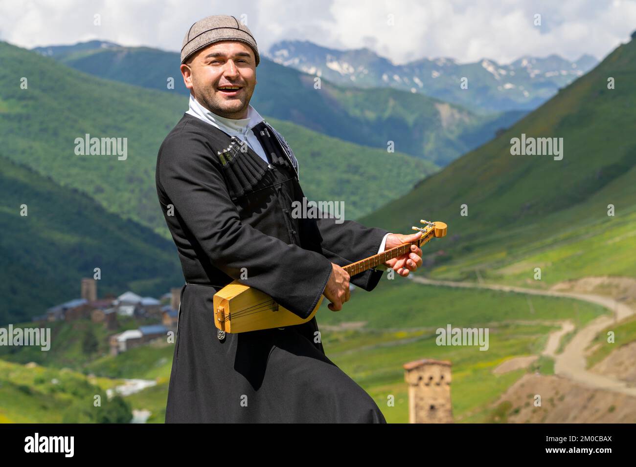 Georgianischer Mann aus der Region Svaneti spielt nationales Musikinstrument von Panduri und singt lokale Lieder in Ushguli, Kaukasus, Georgia. Stockfoto