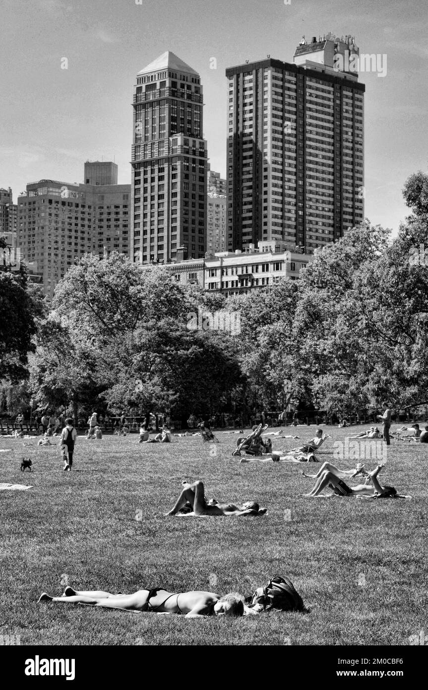 Die Menschen genießen Sheep Meadow im Central Park mit Blick auf die Upper West Side von Manhattan. Stockfoto