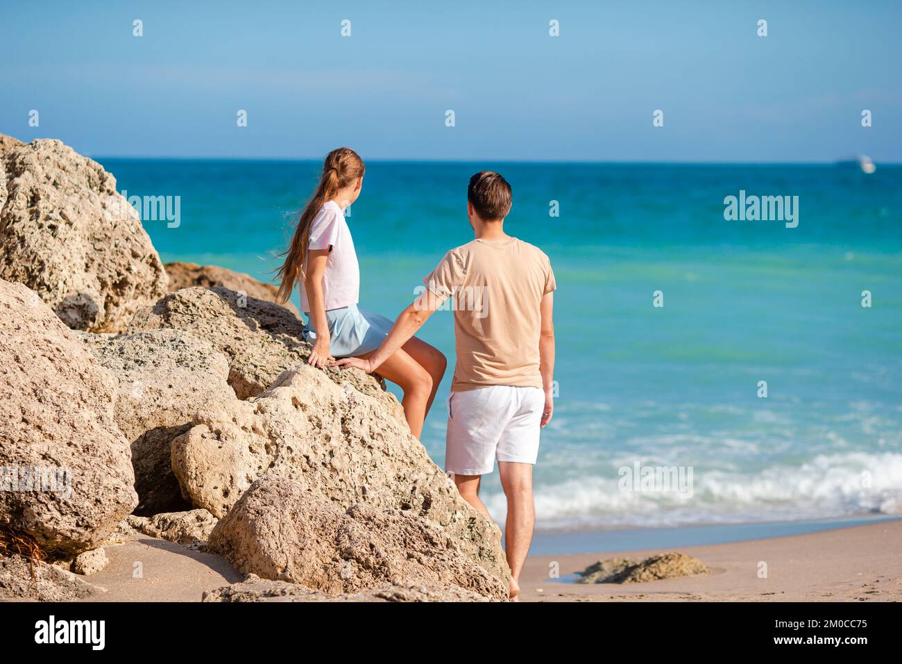Familie von Vater und süße Tochter genießen den Blick auf das Meer am Strand Stockfoto