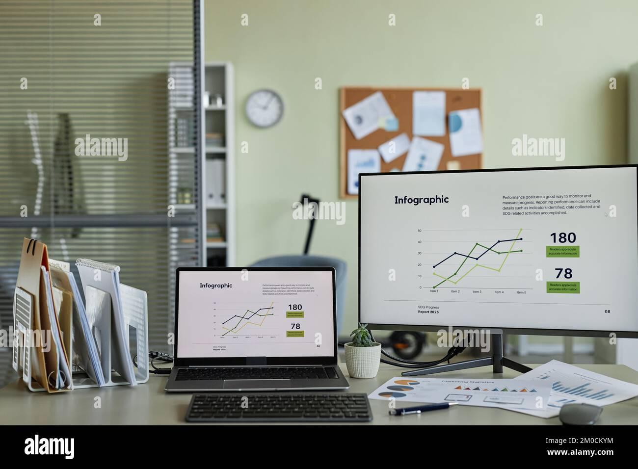 Hintergrundbild von zwei Computern mit Finanzgrafiken und -Diagrammen auf dem Bildschirm am Arbeitsplatz im Büro Stockfoto