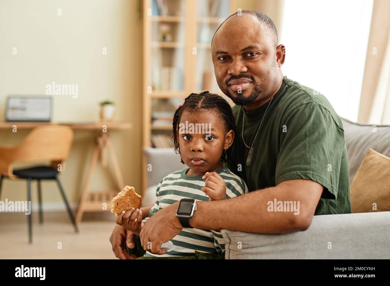 Gemütliches Porträt von schwarzem Vater und schwarzer Tochter, die zu Hause in die Kamera schauen, Kopierraum Stockfoto