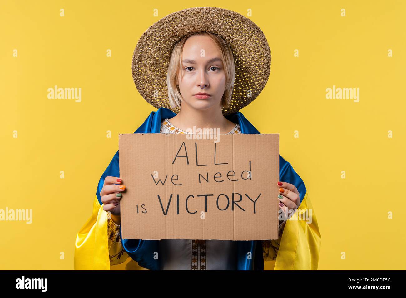 Ukrainerin mit Pappe alles, was wir brauchen, ist Sieg auf gelbem Hintergrund. Die Ukraine wird den Krieg gewinnen. Demokratie, Freiheit, Demonstration, russische Aggresion Stockfoto