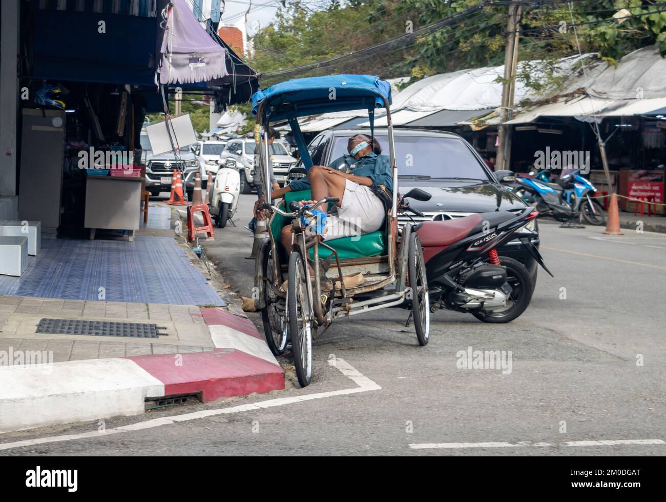 SAMUT PRAKAN, THAILAND, NOVEMBER 23 2022, Ein müder Dreiradfahrer, der auf dem Sitz schläft Stockfoto