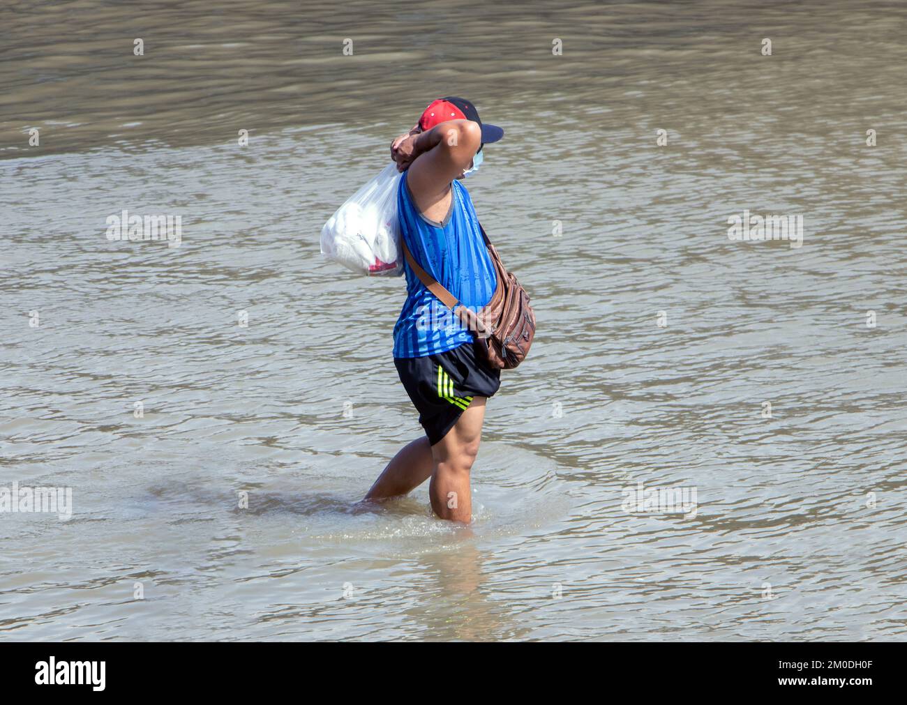 SAMUT PRAKAN, THAILAND, Okt 29 2022, Ein Mann mit einer Tasche läuft im Wasser auf einer überfluteten Straße Stockfoto
