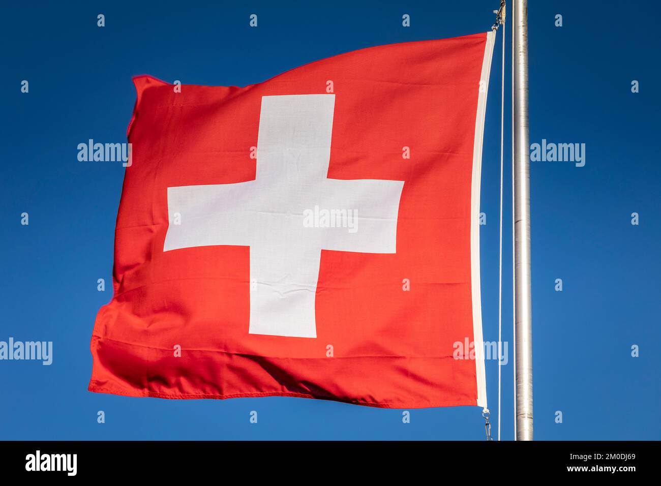 Schweizer Flagge mit blauem Himmel im Hintergrund, Schweizer Alpen Stockfoto