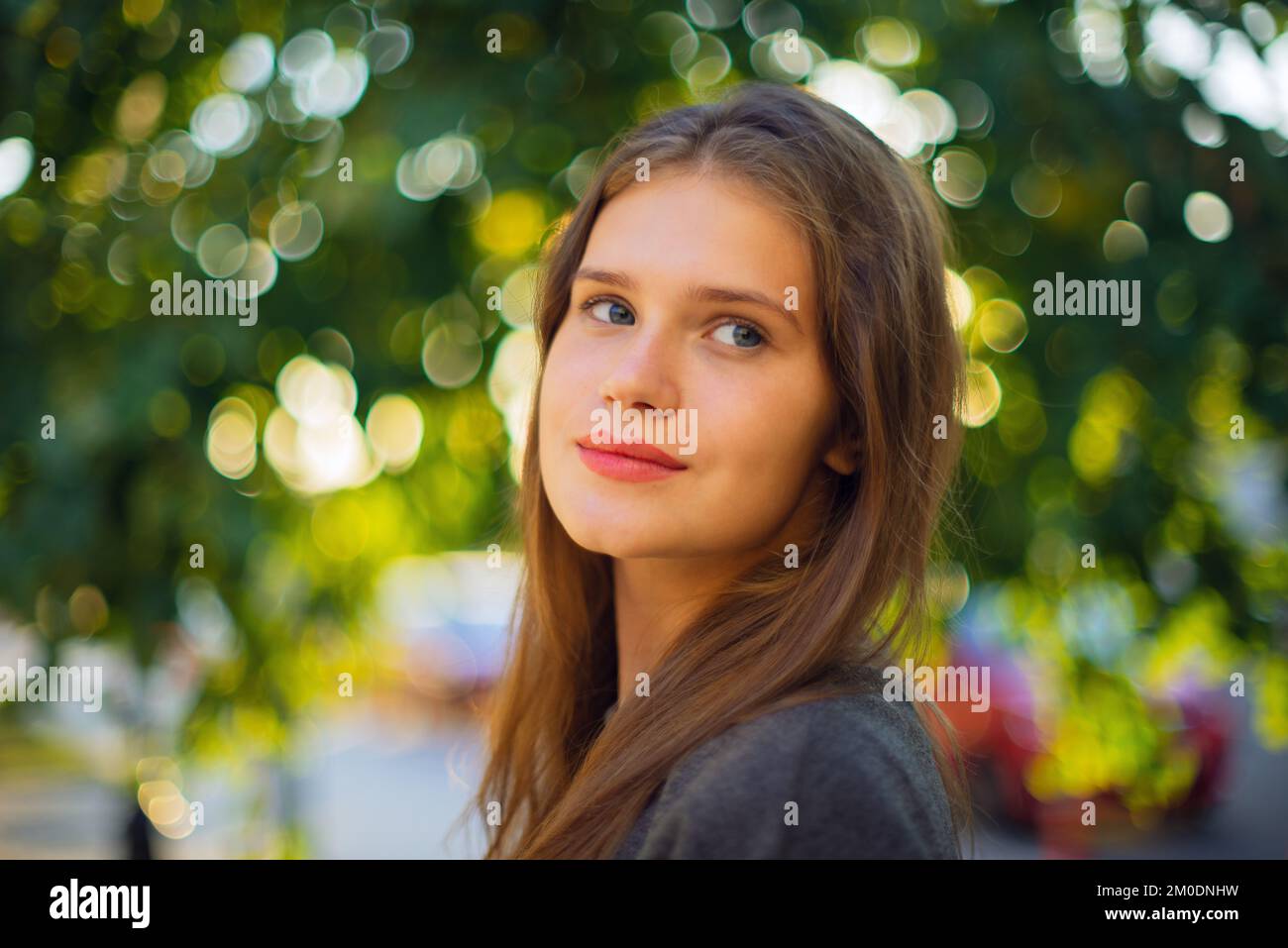 Porträt Einer schönen Brünette jungen Frau der Generation Z, die draußen in die Kamera schaut Stockfoto