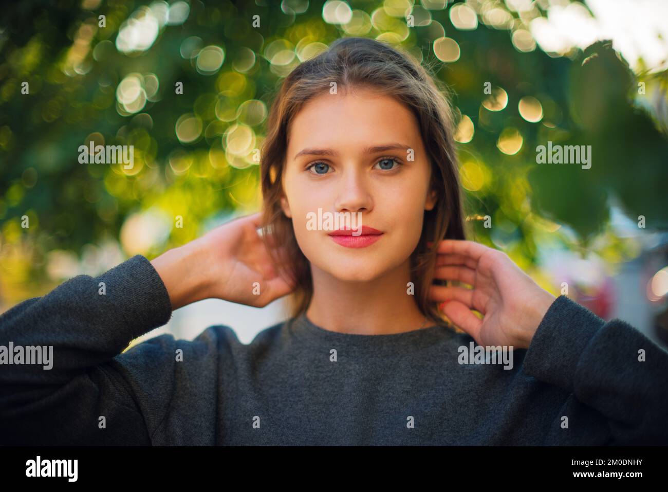 Porträt Einer schönen Brünette jungen Frau der Generation Z, die draußen in die Kamera schaut Stockfoto