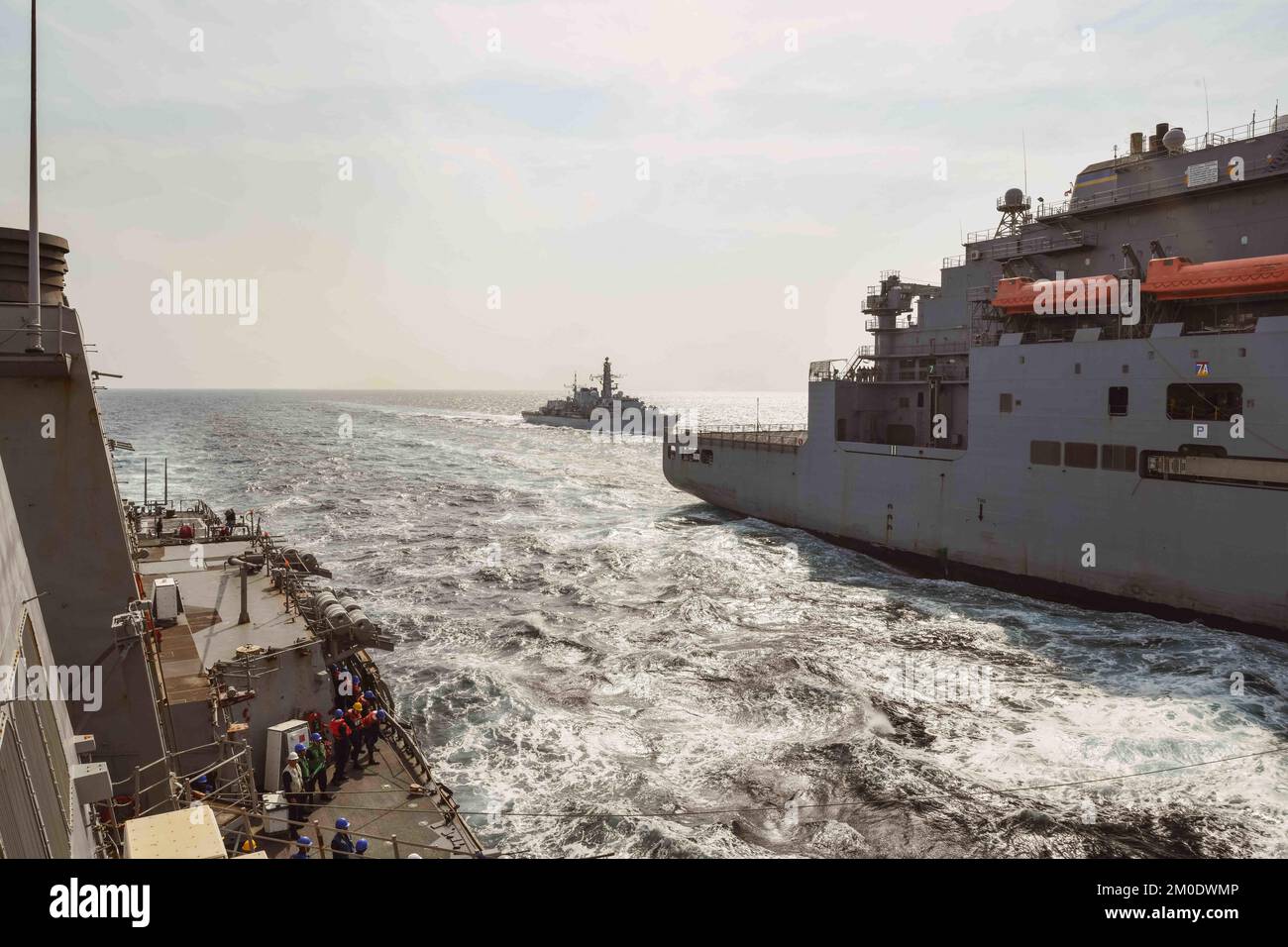 221118-N-RT917-1004 ARABISCHER GOLF (18. NOVEMBER 2022) Geführte Raketenzerstörerin USS die Sullivans (DDG 68) segeln im Arabischen Golf neben dem Trockenfracht- und Munitionsschiff USNS Matthew Perry (T-AKE 9) und dem britischen Royal Navy-Schiff HMS Lancaster (F229), November 18. Die Sullivans werden im US-Flottengebiet 5. eingesetzt, um die Sicherheit und Stabilität der Seeschifffahrt im Nahen Osten zu gewährleisten. (USA Navy-Foto von LT. j.g. Kelly Harris) Stockfoto