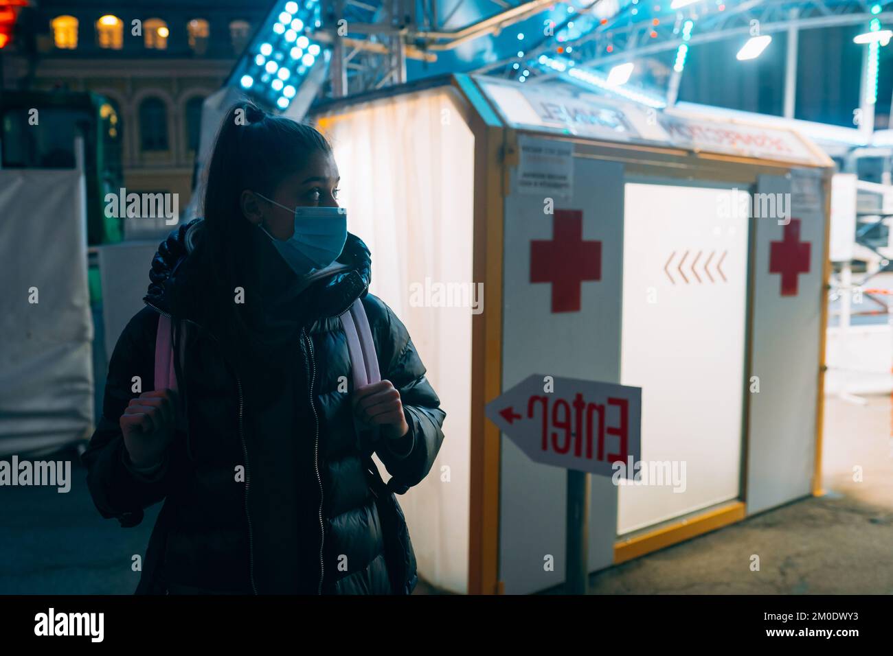 Frau in einer medizinischen Maske befindet sich im Desinfektionstunnel Stockfoto
