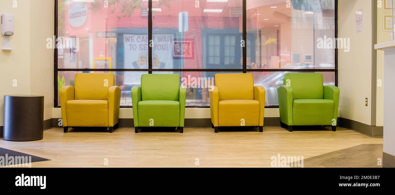 NEW ORLEANS, LA, USA - 16. JUNI 2022: Wartezimmer der Klinik mit farbenfrohen Stühlen und Prytania Bar aus dem Fenster und "Wir können es kaum erwarten, Sie zu sehen" Schild Stockfoto