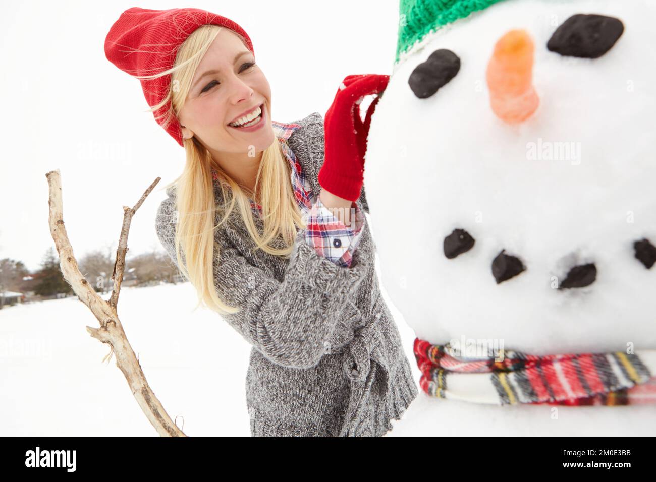 Schneemann, Frau und Happy zu Weihnachten in den Winterferien in Kanadas Landschaft und Frauengebäude mit Schnee für Outdoor-Feiertage Tradition. Lächle mit Stockfoto