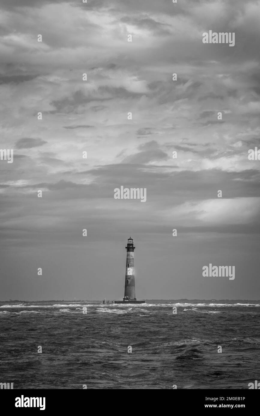 Die vertikale Grauskalenaufnahme am Wasser des Morris Island Lighthouse Stockfoto