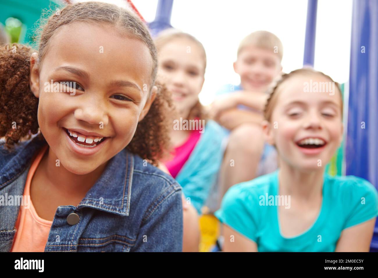 Fröhlicher Optimismus. Eine multiethnische Gruppe glücklicher Kinder, die in einem Dschungelstudio in einem Spielpark spielen. Stockfoto