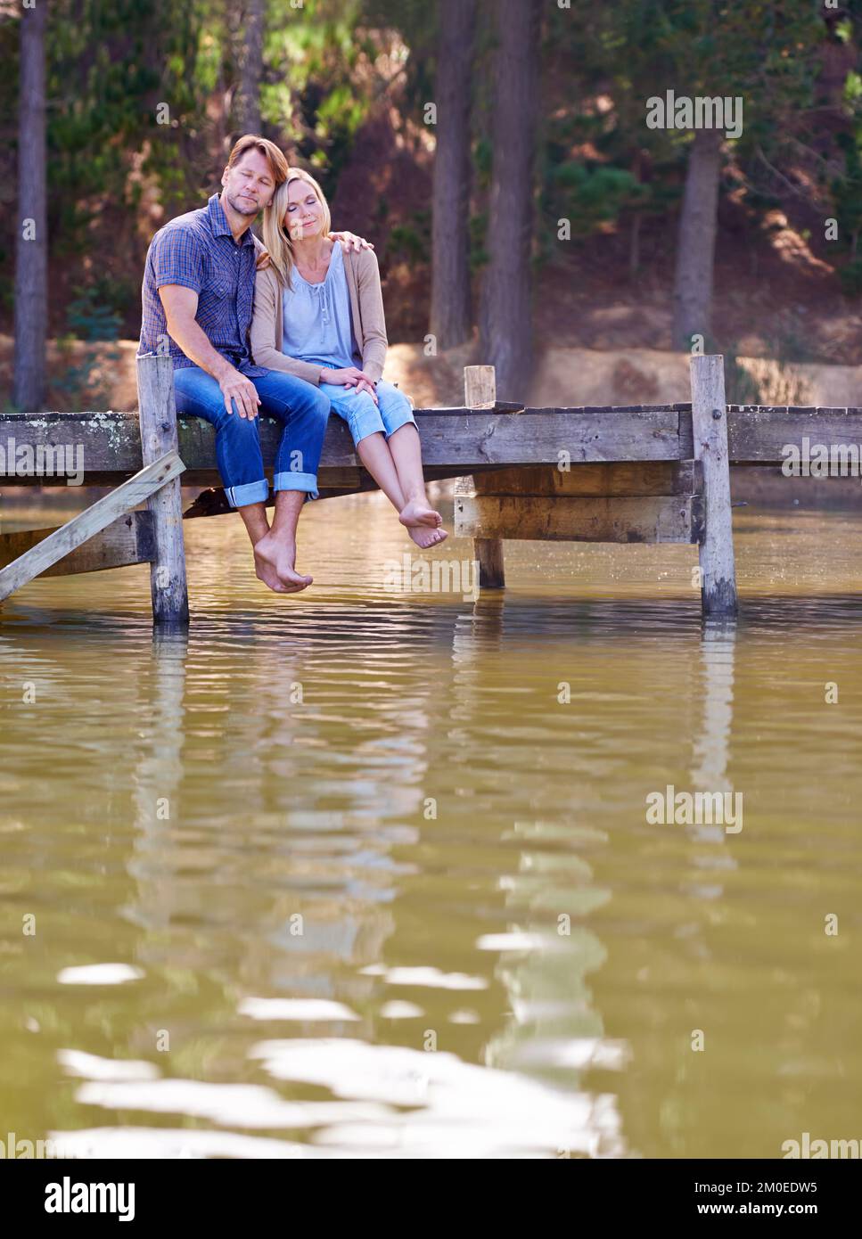 Ich bin froh, dass wir uns diese Zeit genommen haben. Ein liebevolles Ehepaar, das einen Moment auf dem Steg am See genießt. Stockfoto