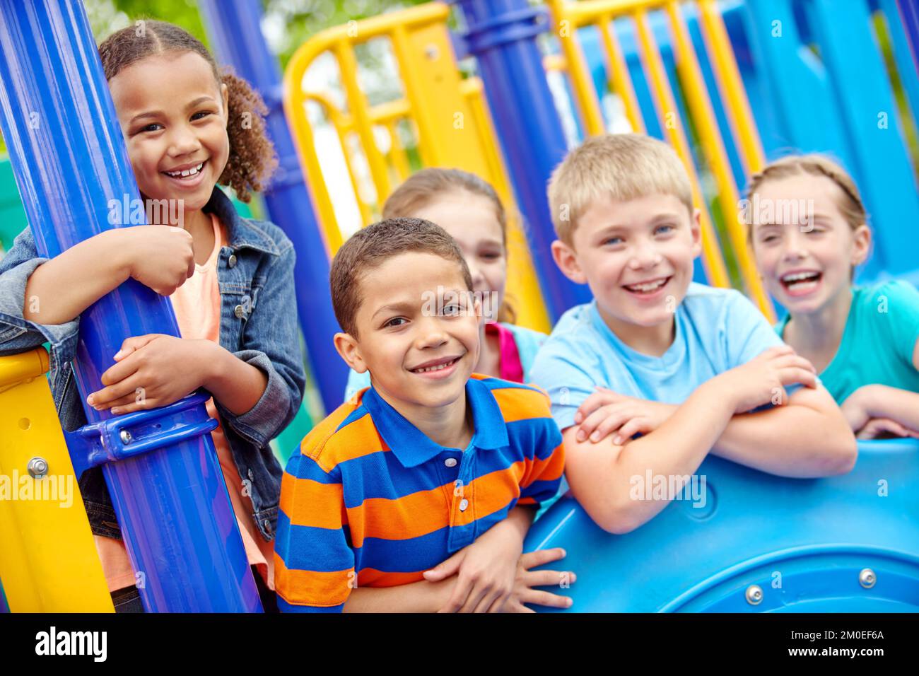 Zusammen aufwachsen. Eine multiethnische Gruppe glücklicher Kinder, die in einem Dschungelstudio in einem Spielpark spielen. Stockfoto