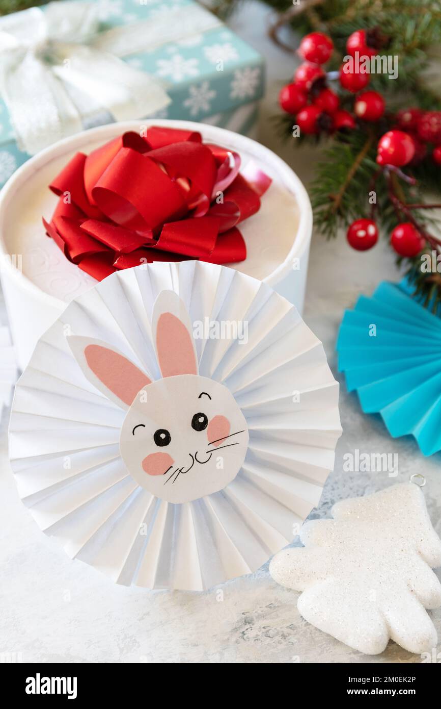 Wintergrußkarte. Weihnachtshintergrund mit Weihnachtsbaum, Geschenkboxen und Symbol des Jahres Mond, chinesischer Kalender, Jahr des Hasen. Stockfoto