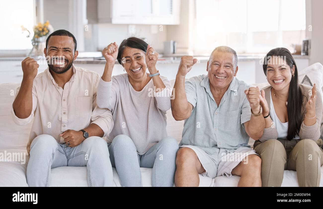 Familienfeiern mit gemischten Rassen, die auf dem Sofa in der Lounge zu Hause sitzen. Die hispanische Familie sieht im Wohnzimmer ekstatisch aus Stockfoto