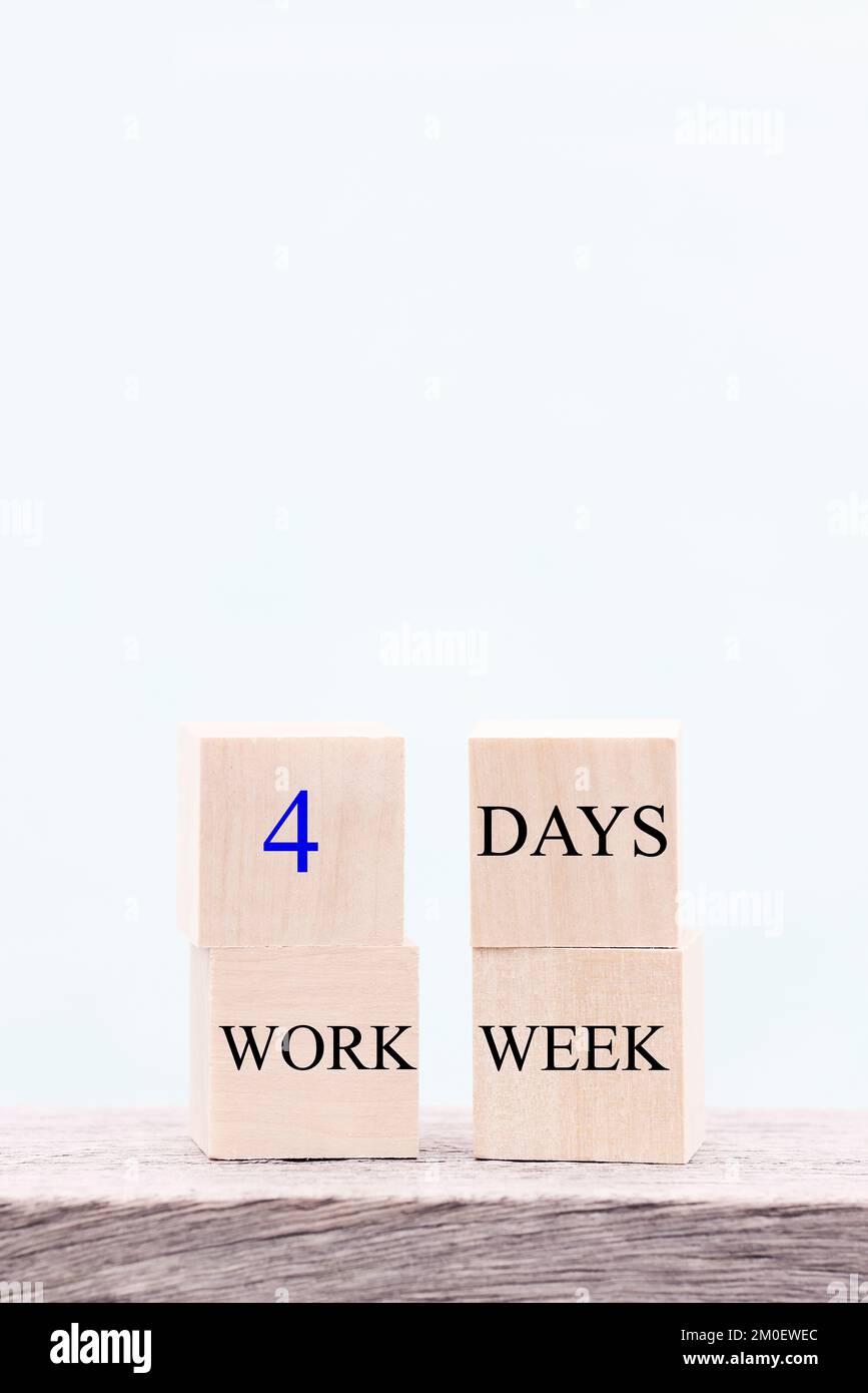 4 Tage Arbeitswoche Wörter auf Holzwürfel auf blauem Hintergrund. Konzept zur Reduzierung von Burnout und Stress. Speicherplatz kopieren Stockfoto