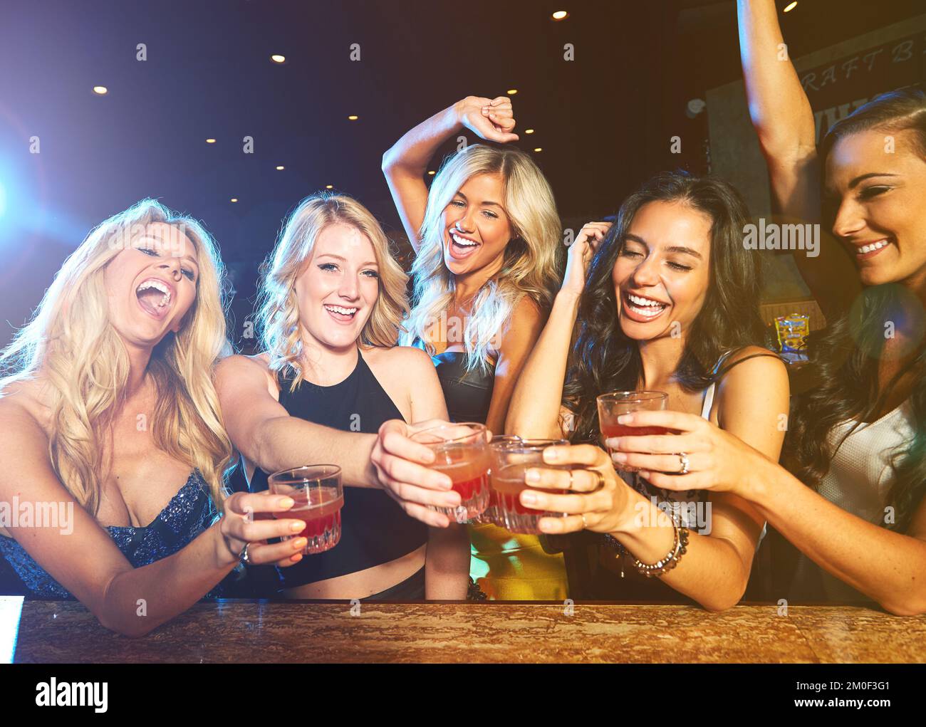 Freunde, Party im Nachtklub mit Cocktails und Toast, Spaß und Glück mit Frauen bei der Neujahrsfeier. Nacht, aufgeregt mit alkoholischen Cocktails Stockfoto