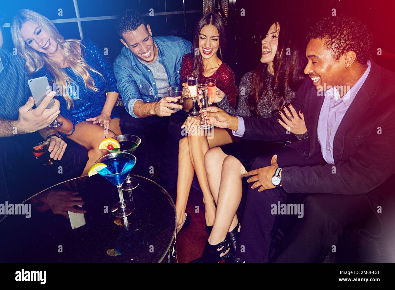 Party, gesellschaftliche Veranstaltung und Freunde stoßen bei einem Abend in einem Nachtclub mit Champagner und Alkohol an. Happy, Cocktail und Lächeln mit Cheers und Drinks fertig Stockfoto