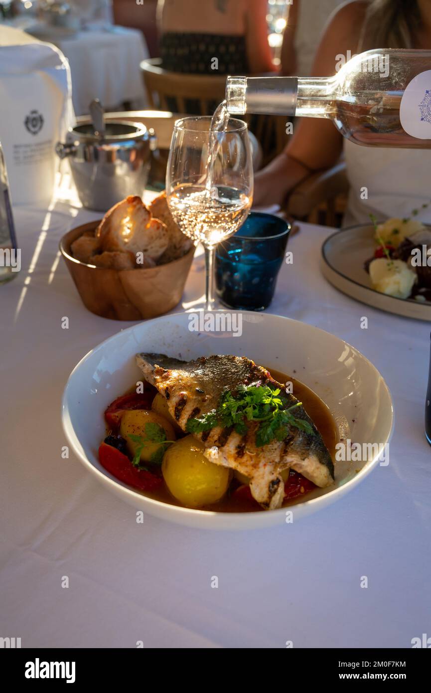 Provenzalische Küche, gegrilltes Weißfischfilet vom Seabarsch, serviert mit Kartoffeln, Tomaten und Bouillabaisse-Fischjus im französischen Restaurant Stockfoto