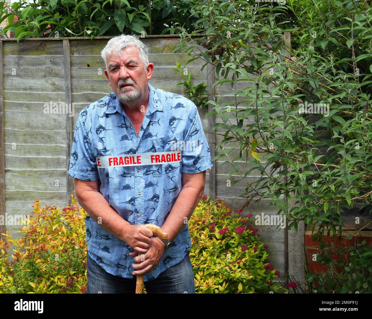 Alter oder älterer Mann, der als zerbrechlich markiert ist. Altersbedingte Schwächen und Beschwerden. Stockfoto